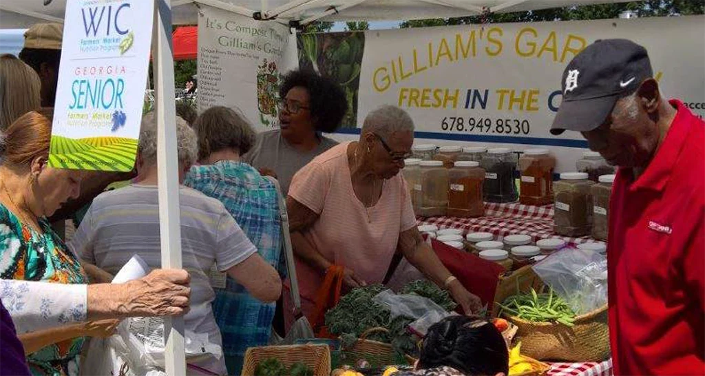 Several people of an older age shopping at a farmers market