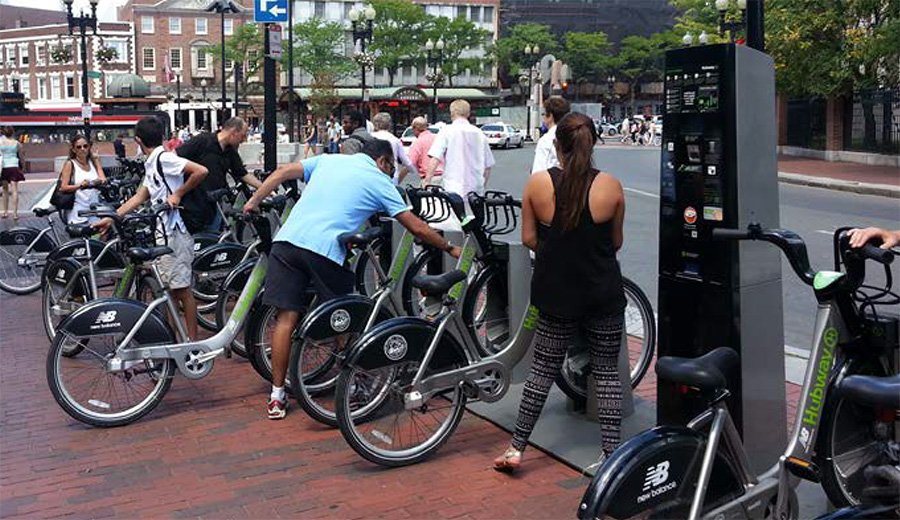 People gathered at an electric bike station with bikes.