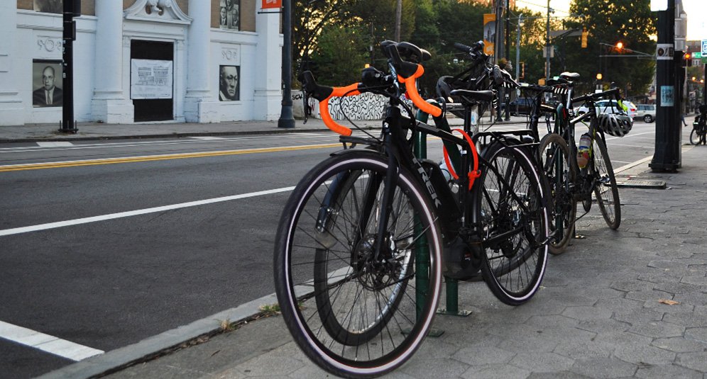 Bikes parked at post along sidewalk