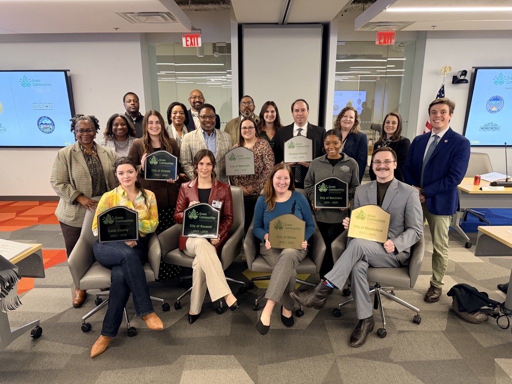 Group seated and standing posing with plaques