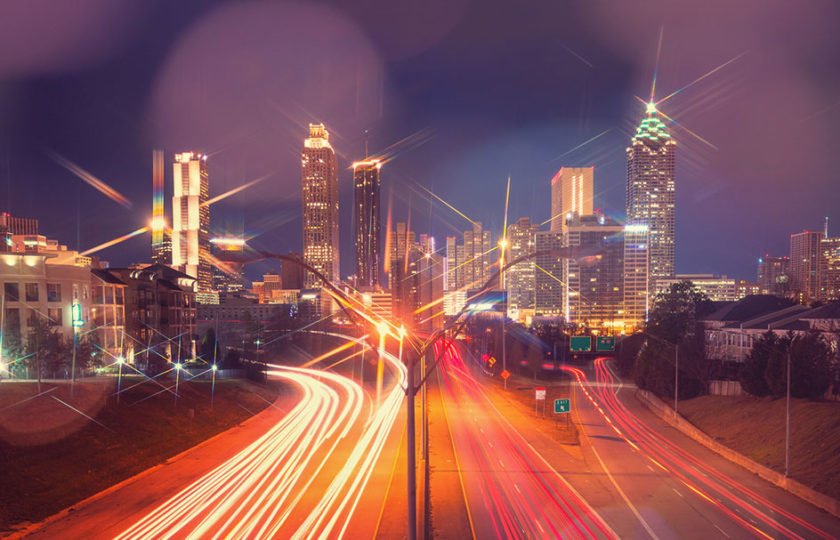Stylized image of downtown Atlanta with ribbons of traffic lights on highway