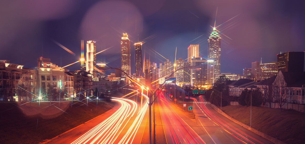 Stylized image of downtown Atlanta with ribbons of traffic lights on highway