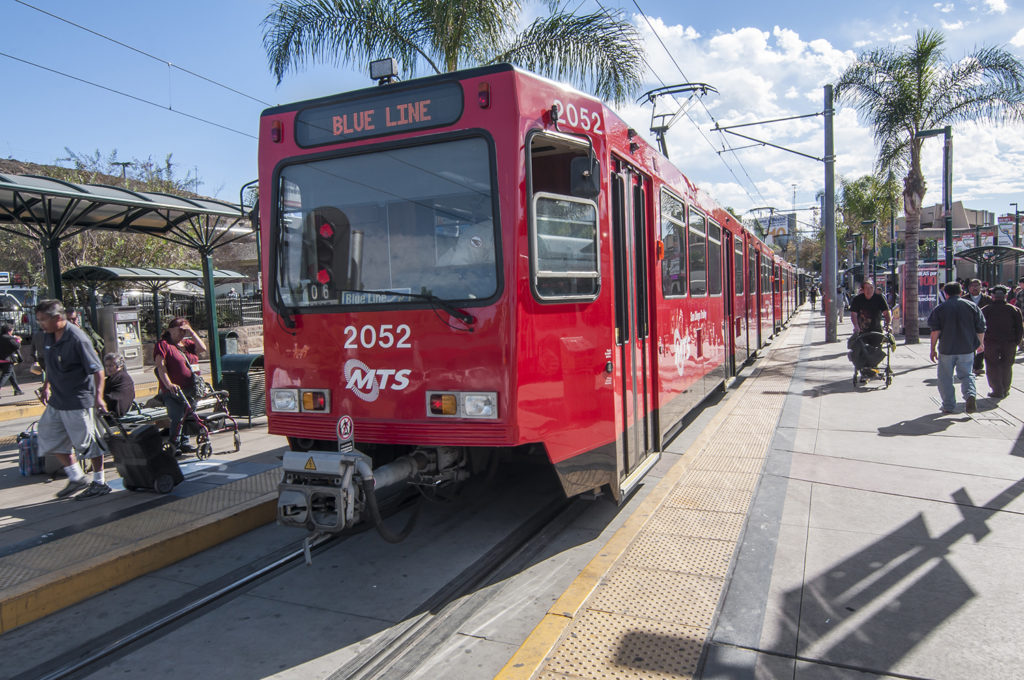 Passengers board and exit the San Diego blue line trolley at the southernmost station stop at the US - Mexico border crossing in San Ysidro on November 27, 2013.