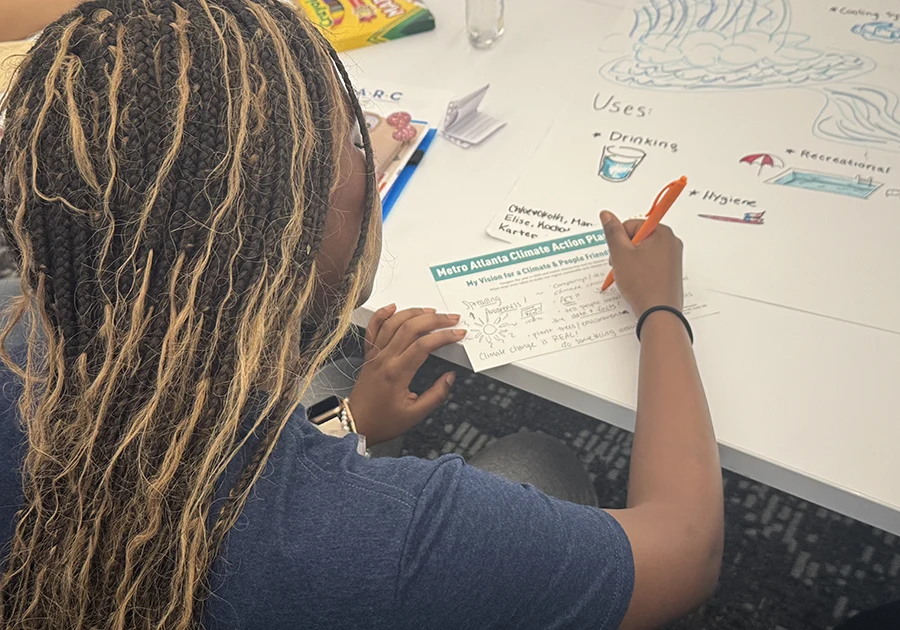 A MARC student writing something down on paper