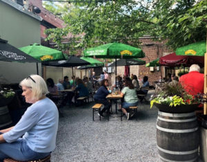 Diners at Brick Store Pub in Decatur sitting at outdoor tables in a former parking lot.