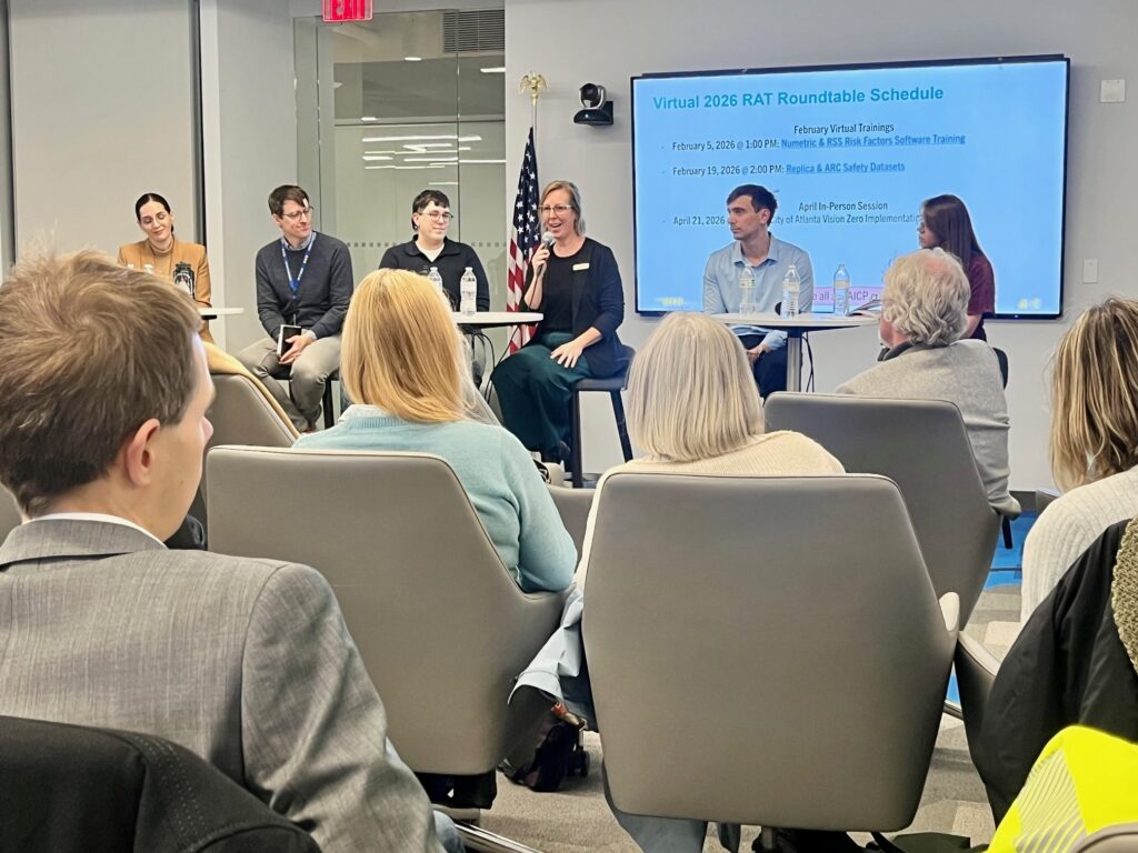 Panel discussion at ARC's Micromobility Symposium. Six panelists sit in front of a room, with audience seated in front of them