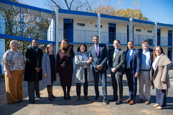 Mayor Andre Dicksons posing with several people in front of the Ralph David house
