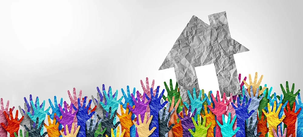 A colorful paper cutout of hands symbolizing housing for everyone.